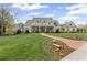 Expansive two-story home features a brick path with lush landscaping and a manicured lawn at 710 Cox Rd, Roswell, GA 30075