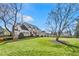 Elegant home surrounded by a green lawn and mature trees, showcasing its curb appeal at 710 Cox Rd, Roswell, GA 30075