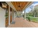 Cozy covered porch with swing seating, wood ceiling, ceiling fans, and brick flooring at 710 Cox Rd, Roswell, GA 30075