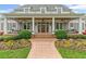 Inviting front porch with swing seating, beautiful landscaping, and a charming brick walkway at 710 Cox Rd, Roswell, GA 30075