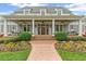 Inviting front porch with swing seating and a brick walkway, framed by beautiful landscaping at 710 Cox Rd, Roswell, GA 30075