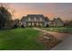 Stunning two-story home at sunset, with a manicured lawn and a charming brick walkway to the entrance at 710 Cox Rd, Roswell, GA 30075