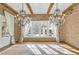 Sun-filled living room featuring brick walls, exposed beams, hardwood floors, and decorative chandeliers at 710 Cox Rd, Roswell, GA 30075