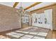 Stunning living room featuring exposed brick walls, wood beams, and elegant chandeliers at 710 Cox Rd, Roswell, GA 30075