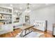 Home office with custom built-ins, natural light, and hardwood floors with an area rug at 710 Cox Rd, Roswell, GA 30075