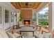 Inviting covered patio features a brick fireplace, wood ceiling, and cozy seating, perfect for outdoor living at 710 Cox Rd, Roswell, GA 30075