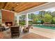 Inviting covered patio with a brick fireplace and comfortable seating near a swimming pool and lush landscaping at 710 Cox Rd, Roswell, GA 30075
