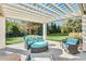 Elegant outdoor pergola with cushioned furniture, offering a peaceful retreat with views of the expansive green lawn at 710 Cox Rd, Roswell, GA 30075