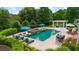 Aerial view of a stunning pool with an integrated hot tub, lounge chairs, and an outdoor dining area at 710 Cox Rd, Roswell, GA 30075