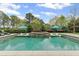 Stunning swimming pool with sun shelves and lounge chairs surrounded by well-maintained landscaping and mature trees at 710 Cox Rd, Roswell, GA 30075