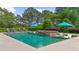A captivating backyard pool with a sun shelf and in-water lounge chairs is surrounded by lush landscaping at 710 Cox Rd, Roswell, GA 30075