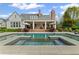 Beautiful pool featuring sun shelves and seamlessly integrated hot tub, set against a backdrop of landscaped grounds at 710 Cox Rd, Roswell, GA 30075