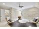 Comfortable seating area with three chairs, a table, wood paneling, and access to a bathroom through an open door at 710 Cox Rd, Roswell, GA 30075