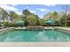 Backyard pool features a tanning ledge, umbrellas, and lush landscaping for a private resort-like experience at 710 Cox Rd, Roswell, GA 30075