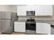 Kitchen boasts white cabinets, granite counters, and stainless steel appliances at 527 Firethorn Ct, Villa Rica, GA 30180