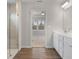 This is a stylish bathroom featuring a glass shower and a double sink vanity with white cabinets at 6945 Melody Dr, Buford, GA 30518