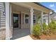 Inviting front porch with decorative columns and a classic black front door at 6945 Melody Dr, Buford, GA 30518