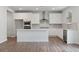 Modern white kitchen featuring an island, stainless appliances, and tile backsplash at 6945 Melody Dr, Buford, GA 30518