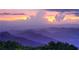 Scenic mountain landscape with layered peaks, colorful sunset, and trees in the foreground at 6945 Melody Dr, Buford, GA 30518