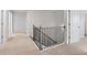 Upstairs hallway with neutral carpeting and black metal railing at 6949 Melody Dr, Buford, GA 30518