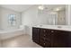 Bathroom features double vanity, soaking tub, and dark wood cabinets at 7633 Summer Berry Ln, Lithonia, GA 30038