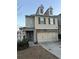 Two-story townhome with brick and siding exterior, two-car garage, and landscaping at 7633 Summer Berry Ln, Lithonia, GA 30038