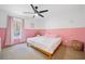 A bedroom with a pink accent wall, wood floors, a bed, and lots of natural light at 2784 Sixes Rd, Canton, GA 30114