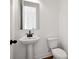 Stylish powder room featuring pedestal sink with black hardware and a modern toilet at 3879 Allegretto Cir # 116, Atlanta, GA 30339