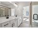 Modern bathroom with a double vanity, a large mirror, black hardware, and a glass-enclosed shower at 3879 Allegretto Cir # 116, Atlanta, GA 30339