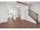 Open-concept space with hardwood floors leading to a modern kitchen and staircase at 3879 Allegretto Cir # 116, Atlanta, GA 30339