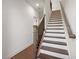 Elegant staircase featuring wood stairs, white risers, and a dark metal railing at 3879 Allegretto Cir # 116, Atlanta, GA 30339