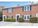 Well-maintained brick townhomes boast black shutters, manicured bushes, and individual entrances at 4195 Jeanette Ct, Norcross, GA 30093