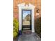 Close-up of a front door with a black frame, flanked by greenery and an address plaque at 4195 Jeanette Ct, Norcross, GA 30093