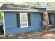 Side view of the house featuring blue siding, a window with dark shutters, and rocking chairs at 4120 Highway 92, Acworth, GA 30102
