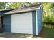 Attached one car garage, blue vinyl siding, and mature trees surround the house at 4120 Highway 92, Acworth, GA 30102