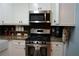 This kitchen offers stainless steel appliances, white cabinetry, and granite countertops at 4120 Highway 92, Acworth, GA 30102