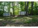 Two large storage sheds with a dog house located in the wooded backyard at 4120 Highway 92, Acworth, GA 30102