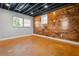 Finished basement with exposed ceiling, a wooden panel wall and windows for natural light and ventilation at 5333 Pine Valley Rd, Powder Springs, GA 30127