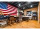 Finished basement with an office space, a retro arcade game, exposed ceiling and a large American flag as decor at 5333 Pine Valley Rd, Powder Springs, GA 30127