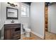 Finished basement bathroom with a dark wooden vanity, framed mirror, new toilet, and a window for natural light at 5333 Pine Valley Rd, Powder Springs, GA 30127