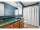 Bathroom with dark blue walls, vanity sink, and walk-in shower with curtain at 5333 Pine Valley Rd, Powder Springs, GA 30127