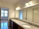 Bathroom boasting double sink vanity with granite countertop and a large frameless mirror at 10340 Meadow Crest Ln, Alpharetta, GA 30022