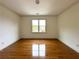 Spacious empty bedroom with hardwood floors, neutral paint, and a large window at 10340 Meadow Crest Ln, Alpharetta, GA 30022