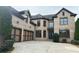 Spacious brick home with a three-car garage, large driveway, and well-maintained landscaping at 10340 Meadow Crest Ln, Alpharetta, GA 30022