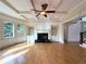 Spacious living room with hardwood floors, a coffered ceiling, built-in bookshelves, and a fireplace at 10340 Meadow Crest Ln, Alpharetta, GA 30022
