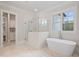 Bathroom featuring a soaking tub, glass shower, and marble floors at 325 Mont Harmony Sw Rd, Powder Springs, GA 30127