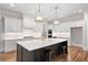 Island kitchen with white cabinets, quartz counters and gold fixtures at 325 Mont Harmony Sw Rd, Powder Springs, GA 30127