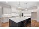 Island kitchen with white cabinets, quartz counters and gold fixtures at 325 Mont Harmony Sw Rd, Powder Springs, GA 30127