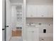 Bright laundry room with white cabinets, built-in bench and patterned tile floor at 325 Mont Harmony Sw Rd, Powder Springs, GA 30127