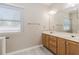 Bright bathroom featuring double sink vanity, wood cabinets, modern lighting, and a large mirror at 1019 Walnut Creek Dr, Woodstock, GA 30188